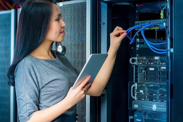 A female network engineer working on a router system.