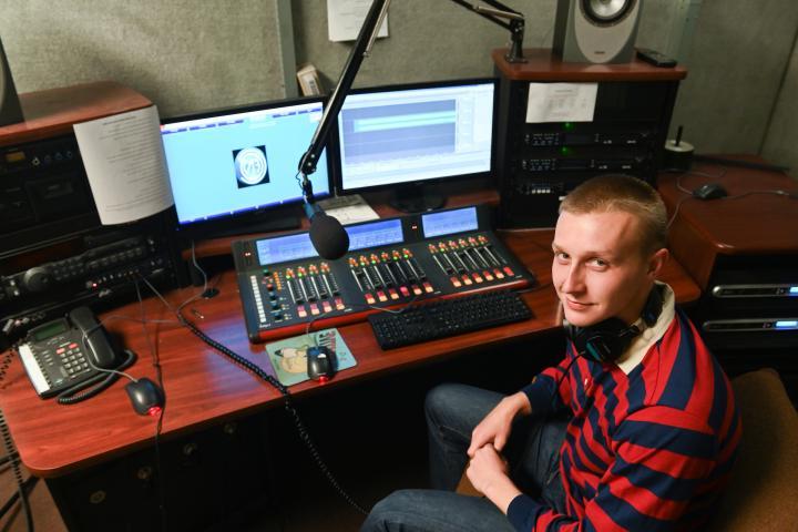 Student sits in front of Perch radio equipment 